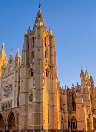 Catedral de León al atardecer, edificio gótico francés conocido como Pulchra Leonina, bajo un cielo azul despejado.