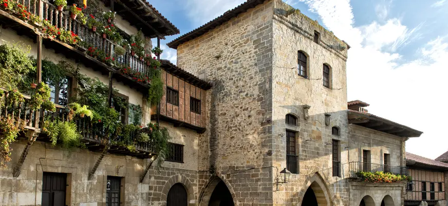 Arquitectura histórica medieval con balcones floridos en Santillana del Mar, Cantabria.