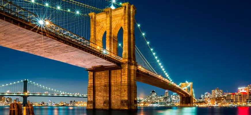 **Alt sugerido (≤80 caracteres):** Puente de Brooklyn iluminado de noche con el skyline de Nueva York