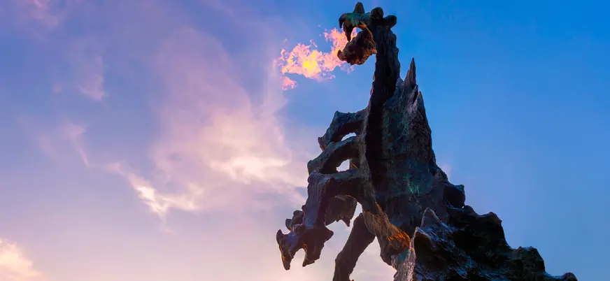 Escultura del dragón de Wawel lanzando fuego al atardecer en Cracovia, Polonia