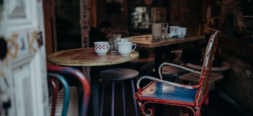 Interior de un bar-ruina de Budapest con mesas y sillas vintage desgastadas