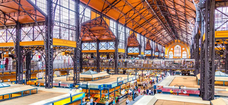 Interior del Mercado Central de Budapest con puestos de productos y estructura de hierro