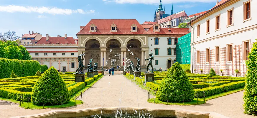 Jardín del Palacio Wallenstein en Praga con setos, esculturas y fuente.