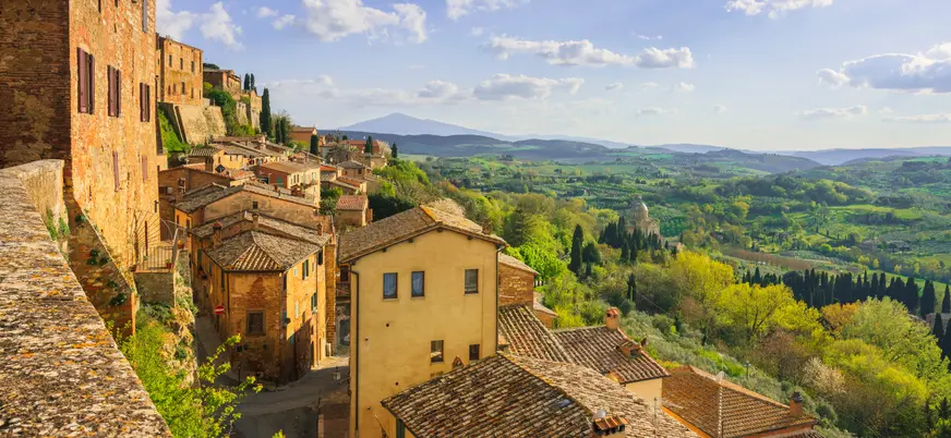  Vista panorámica desde un mirador en Montepulciano, con colinas verdes salpicadas de árboles y parte del pueblo