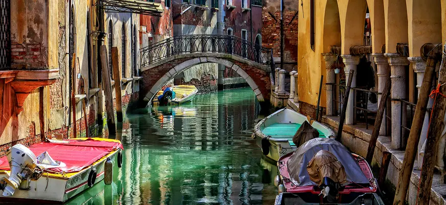 Vista de uno de los canales de Venecia, con un pequeño puente y góndolas