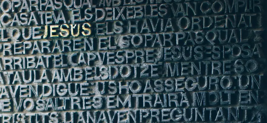 Puerta de bronce de la Sagrada Familia con relieve de texto en Barcelona.