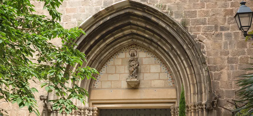 Portada gótica con escultura en una iglesia del Barrio Gótico.