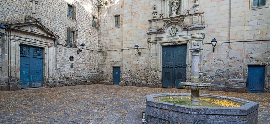 Plaza de Sant Felip Neri con su fuente y fachada marcada por impactos.