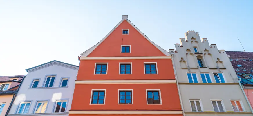 Fachadas coloridas y tradicionales en una calle luminosa.