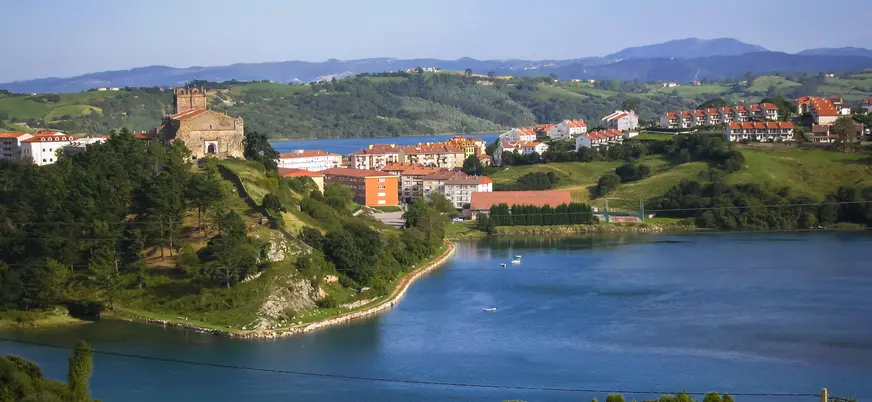 Vista de San Vicente de la Barquera con la iglesia de Santa María de los Ángeles en lo alto, junto a la ría.