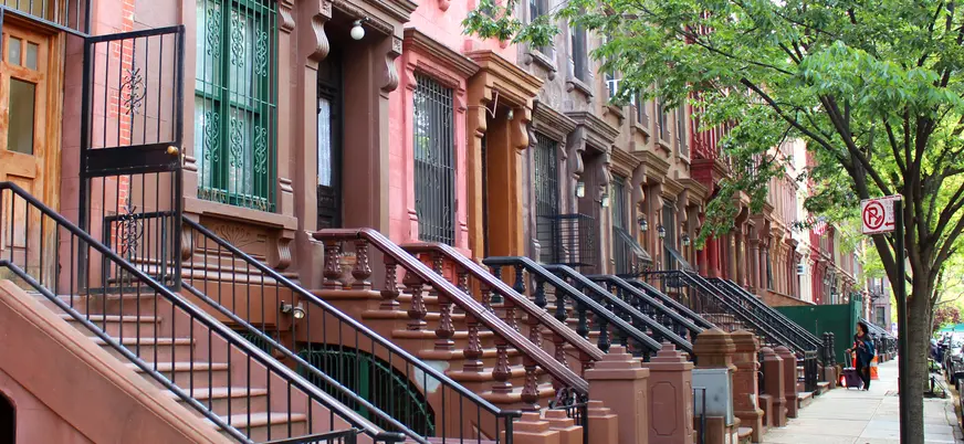 Brownstones tradicionales en una calle residencial de Harlem, Nueva York, Estados Unidos