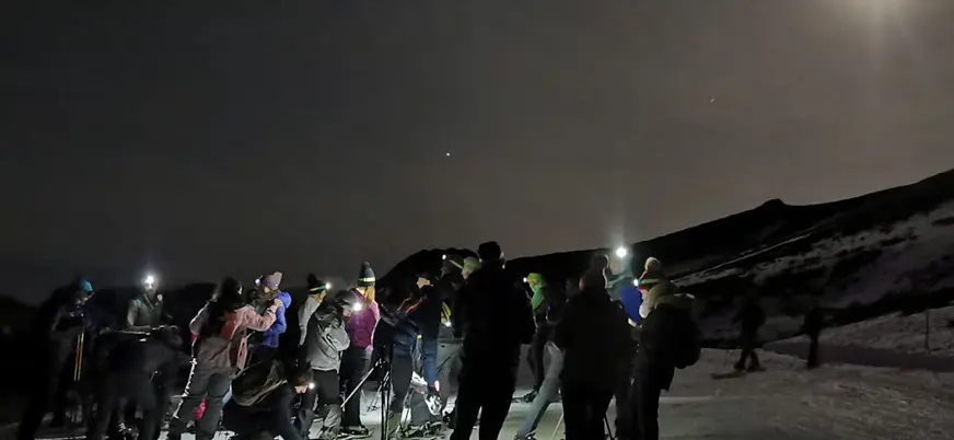 Grupo equipándose con raquetas y frontales en Fuentes de Invierno