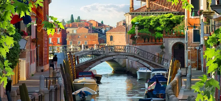 Canal con puente y barcas en un barrio tranquilo de Venecia