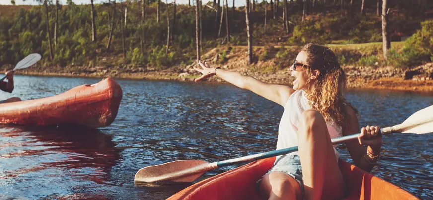Dos personas disfrutando de un descenso en kayak por el río Asón