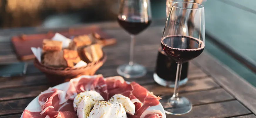 Aperitivo italiano compuesto de embutido, queso y vino de Chianti