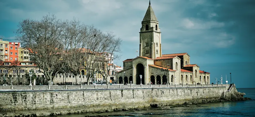 Iglesia de San Pedro Apóstol junto al mar Cantábrico, uno de los lugares más icónicos del paseo marítimo de Gijón, Asturias.