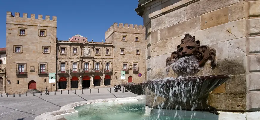 Fuente del Monumento a Pelayo con el Palacio de Revillagigedo al fondo, en el casco histórico de Gijón, Asturias