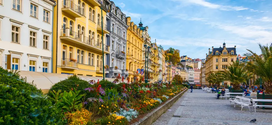 Fila de edificios coloridos y fuente de agua en la calle principal de Karlovy Vary.