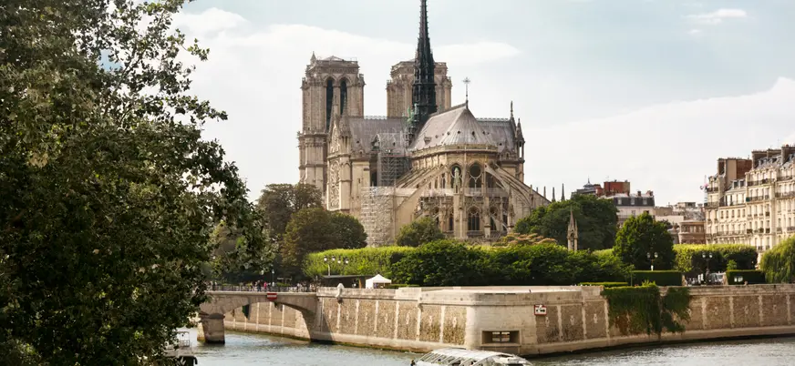 Un bote se desplaza por el río junto al imponente edificio de Notre Dame.