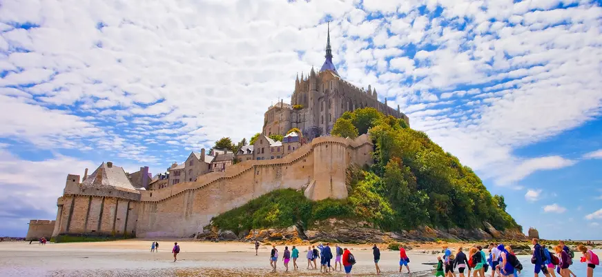 Claustro ajardinado y fachada gótica de la abadía del Mont Saint-Michel en Normandía, Francia.