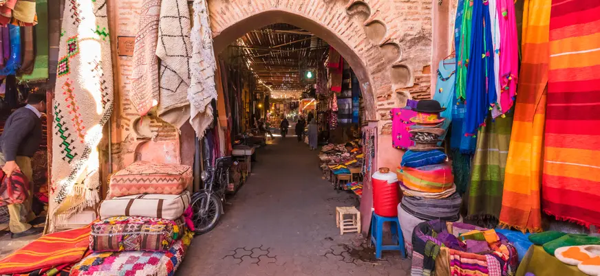 Calle de los zocos en la medina de Marrakech con puestos de artesanía