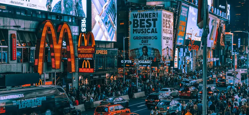 Multitud y carteles luminosos en Times Square de noche, Nueva York, Estados Unidos