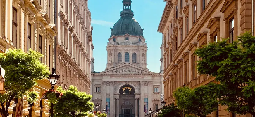 La Basílica de San Esteban en Budapest vista desde una calle arbolada.