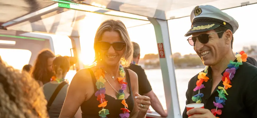 Personas disfrutando de una fiesta en barco al atardecer en Oporto.