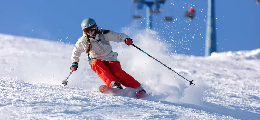 Esquiadora en pista de Fuentes de Invierno con material adaptado a su nivel, Asturias