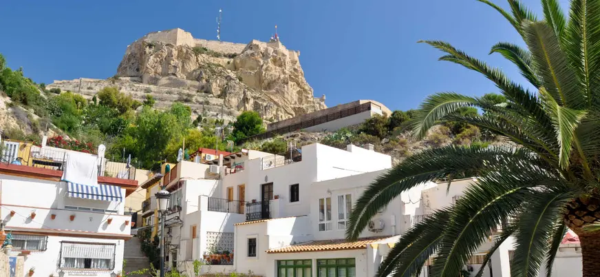 Casas blancas del barrio de Santa Cruz con vista al castillo de Santa Bárbara en Alicante