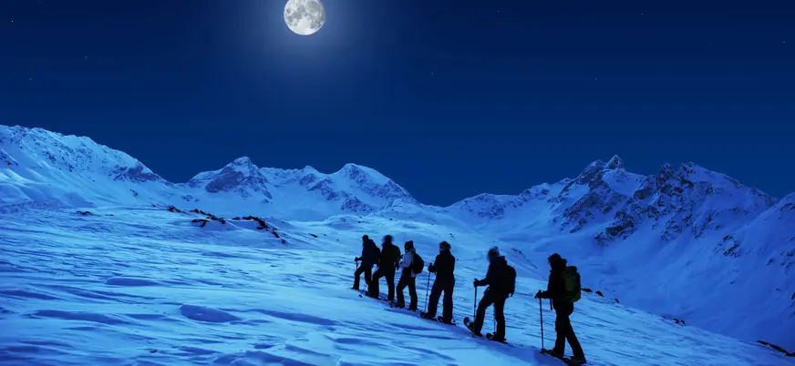 Ruta nocturna en raquetas de nieve a la luz de la luna en Fuentes de Invierno