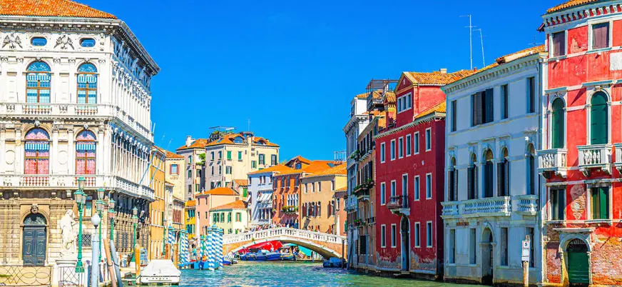 Puente sobre canal rodeado de edificios coloridos en el centro histórico de Venecia