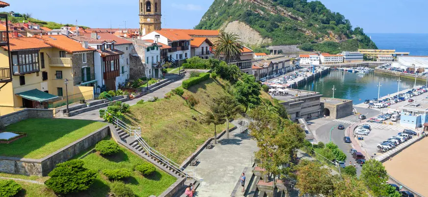 Vista del puerto de Getaria con casas tradicionales y monte en la costa vasca