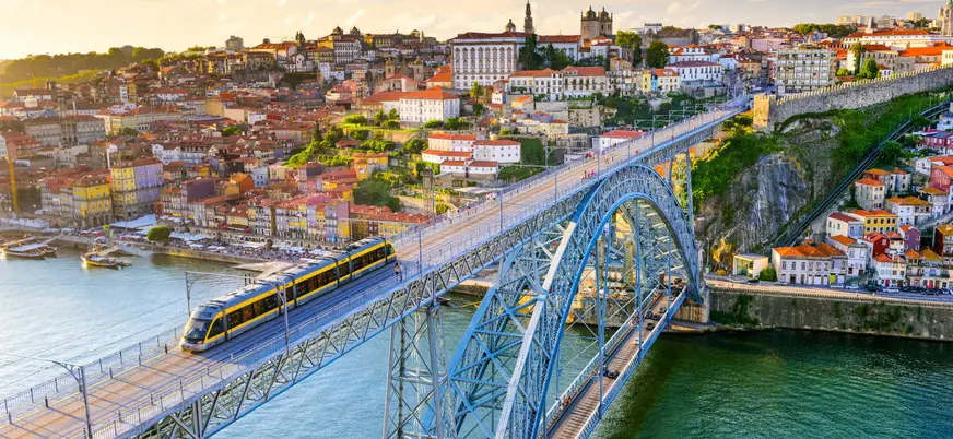 Puente Don Luis I con tranvía cruzando el río Duero al atardecer en Oporto.