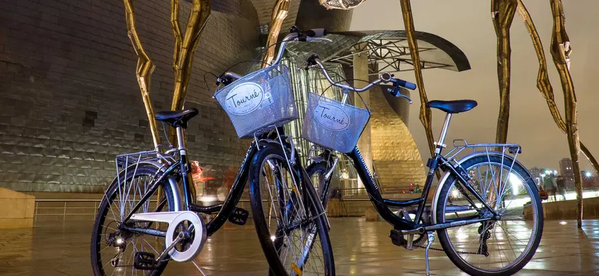 Bicicletas del tour frente al Museo Guggenheim Bilbao al anochecer
