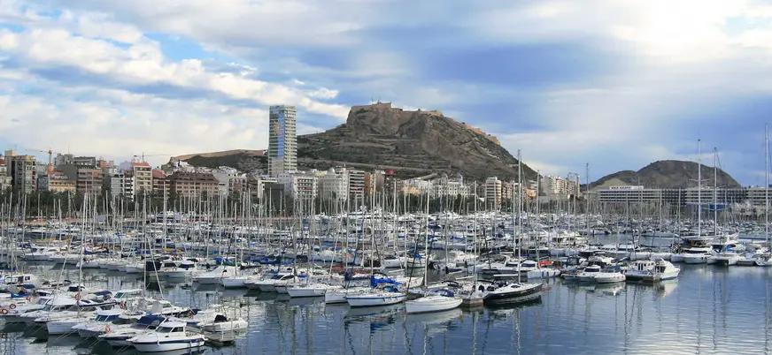 Puerto de Alicante con barcos y vista al castillo de Santa Bárbara al fondo