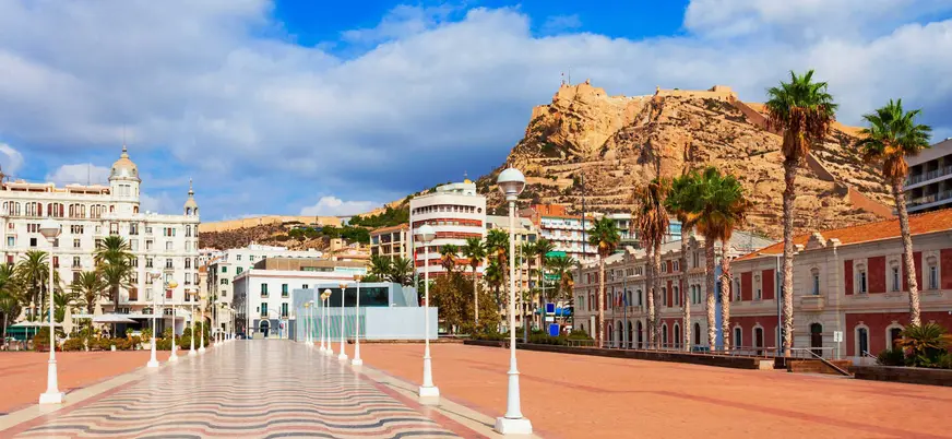 Explanada de España con mosaico ondulado y vista al castillo de Santa Bárbara en Alicante