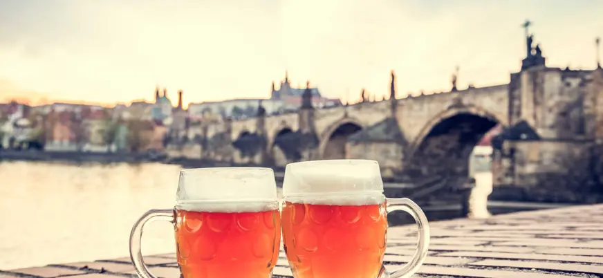 Dos cervezas junto al Puente de Carlos al atardecer en Praga