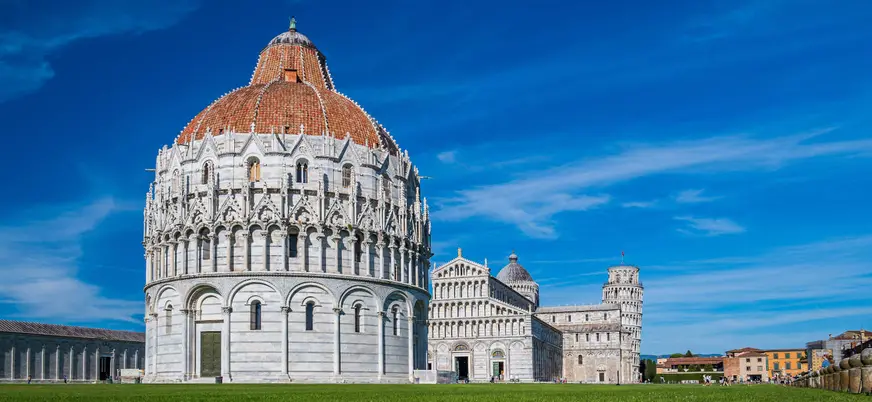 Vista del Baptisterio de Pisa, edificio circular de estilo románico y gótico, con cúpula y detalles arquitectónicos en mármol blanco, situado en la Piazza dei Miracoli.