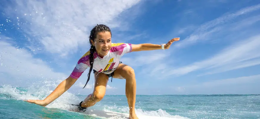 Clase de surf en Llanes, Asturias, con surfista sobre la ola
