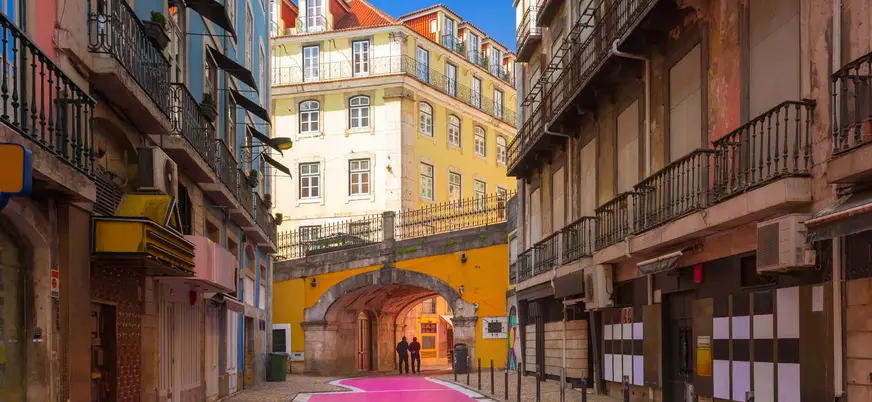 La famosa Calle Rosa de Lisboa, bajo un arco amarillo en el Barrio Alto.
