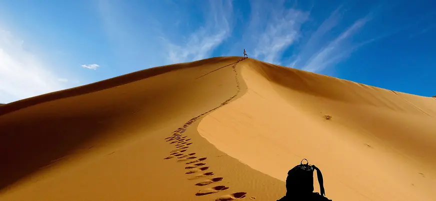 Dunas del desierto de Merzouga al atardecer con huellas sobre la arena
