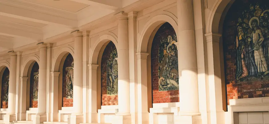 Galería porticada del Santuario de Fátima, Portugal, con mosaicos religiosos.