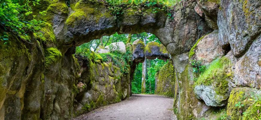 Sendero entre rocas cubiertas de musgo en los jardines de Quinta da Regaleira en Sintra.