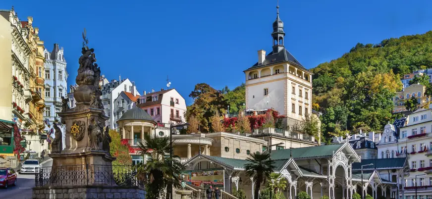 Estatua frente a la Torre del Mercado y arquitectura balnearia en Karlovy Vary