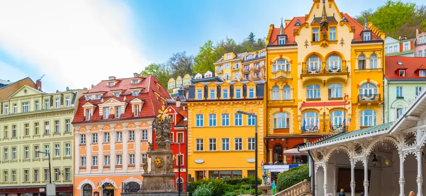 Edificios balnearios de colores vibrantes en la orilla del río de Karlovy Vary.