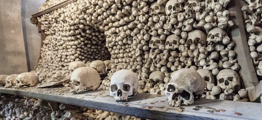 Estante con calaveras y una pared cubierta de huesos en el Osario de Sedlec, Kutná Hora.