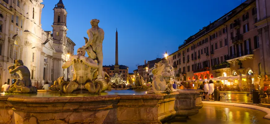 Vista de Roma al atardecer con la Columna de Trajano, ruinas arqueológicas y las iglesias barrocas de Santa Maria di Loreto y Santissimo Nome di Maria.