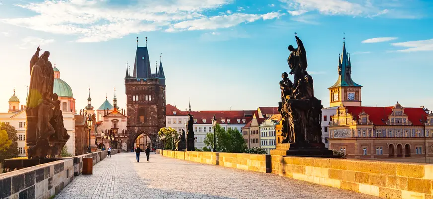 Puente de Carlos al amanecer con esculturas y la Torre de la Ciudad Vieja en Praga