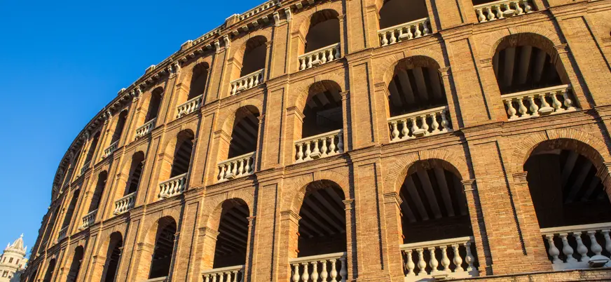Fachada neoclásica de la Plaza de Toros de Valencia iluminada por el sol